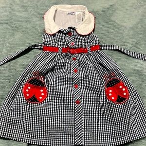 Blue and white squared girls dress with red accents, sleveless.